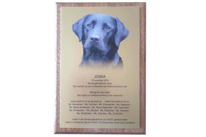 Plaquette of jubileum bord met aluminium onderdruk en gemonteerd op een houten onderplaat met tekst en een foto van een hond