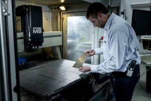 Medewerker Gravure85 controleert het graveerwerk van het metalen plaatje